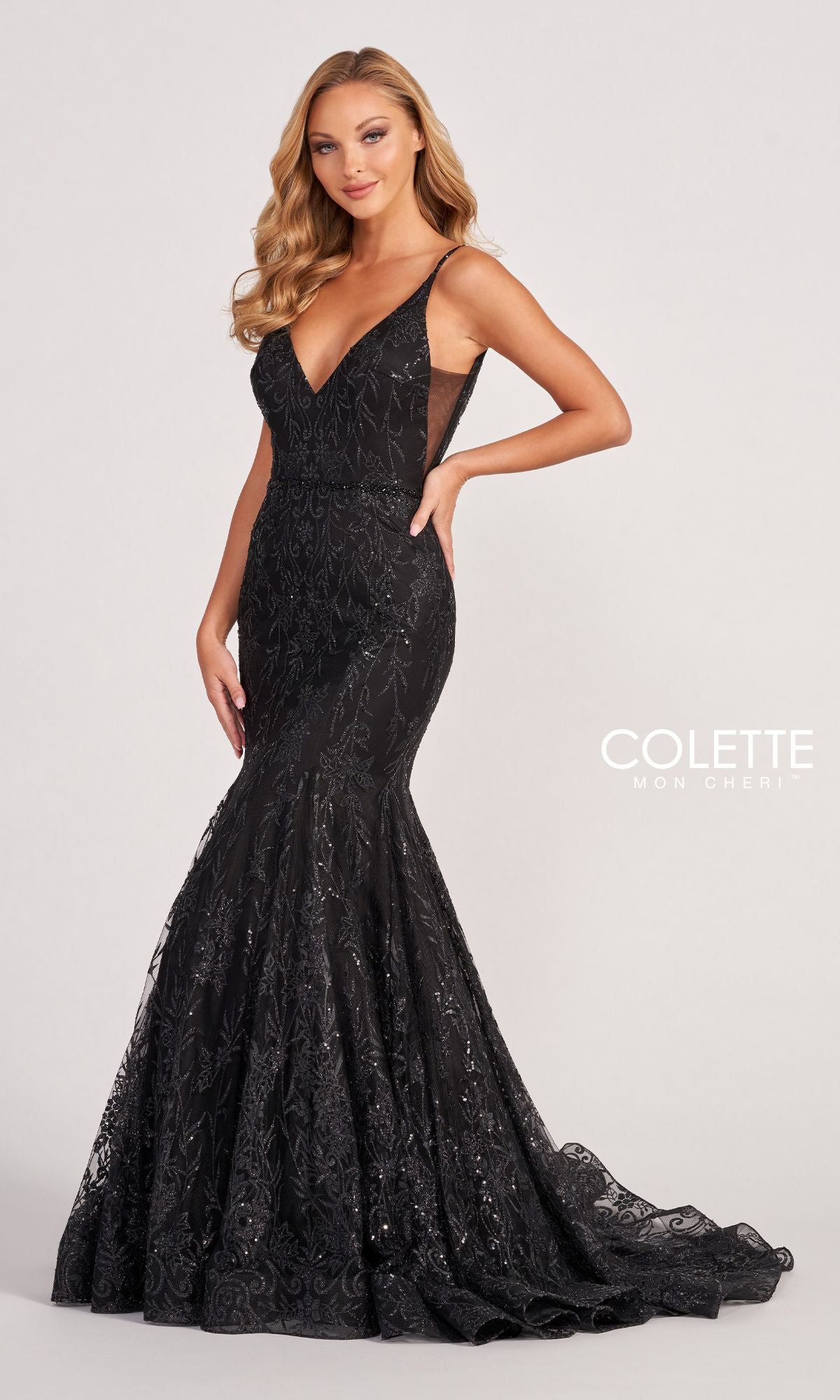 A woman poses against a plain background in the Colette CL2021 Long Mermaid Glitter Prom Dress, a floor-length black sleeveless gown with sequin details. The
